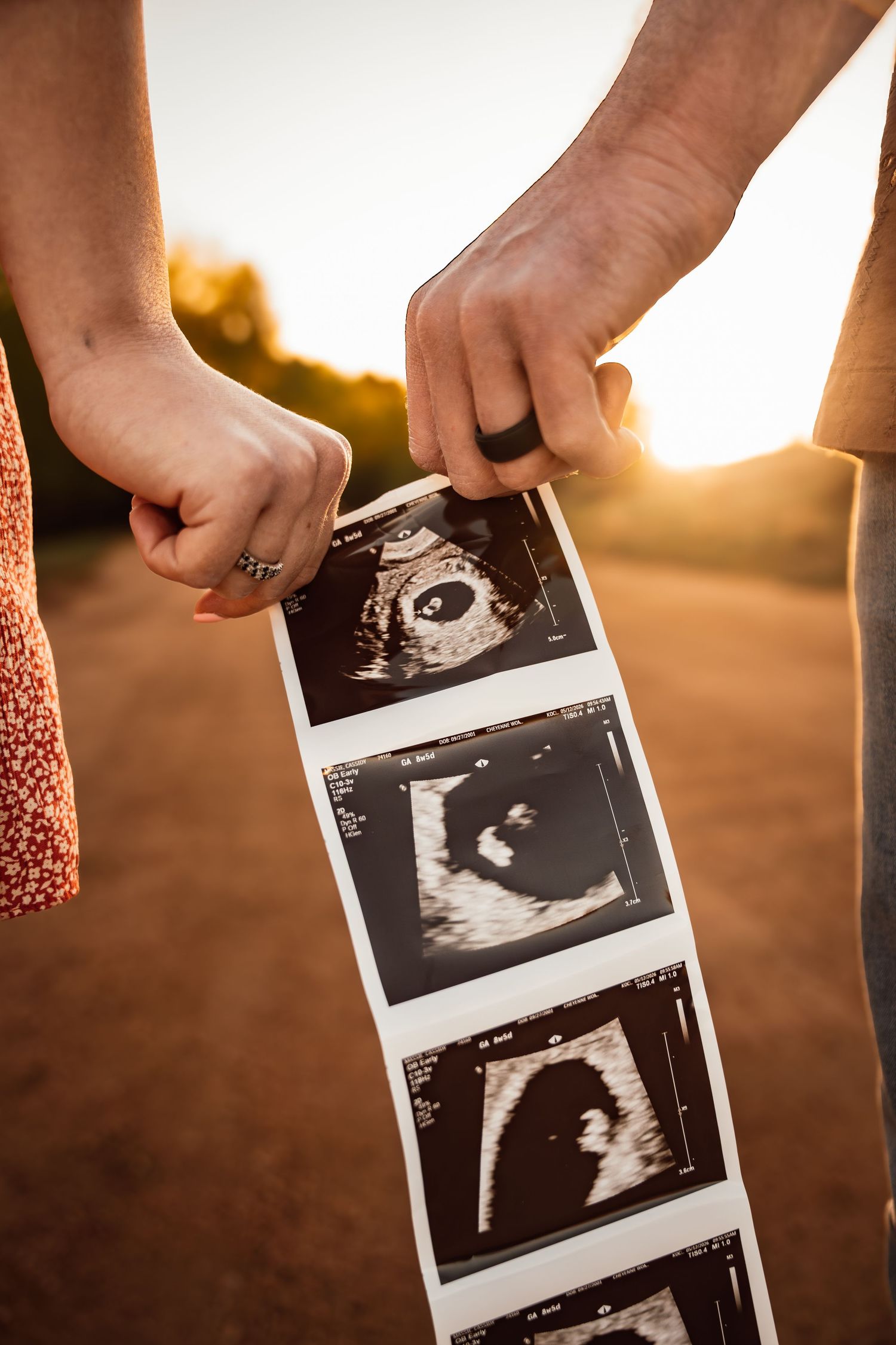 A maternity photo showing a pregnant woman in orange lace against a white backdrop.