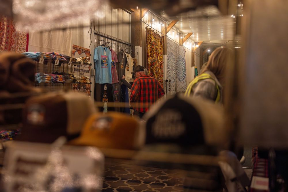 Blurred motion shot of a clothing store interior with warm lighting and racks of merchandise.