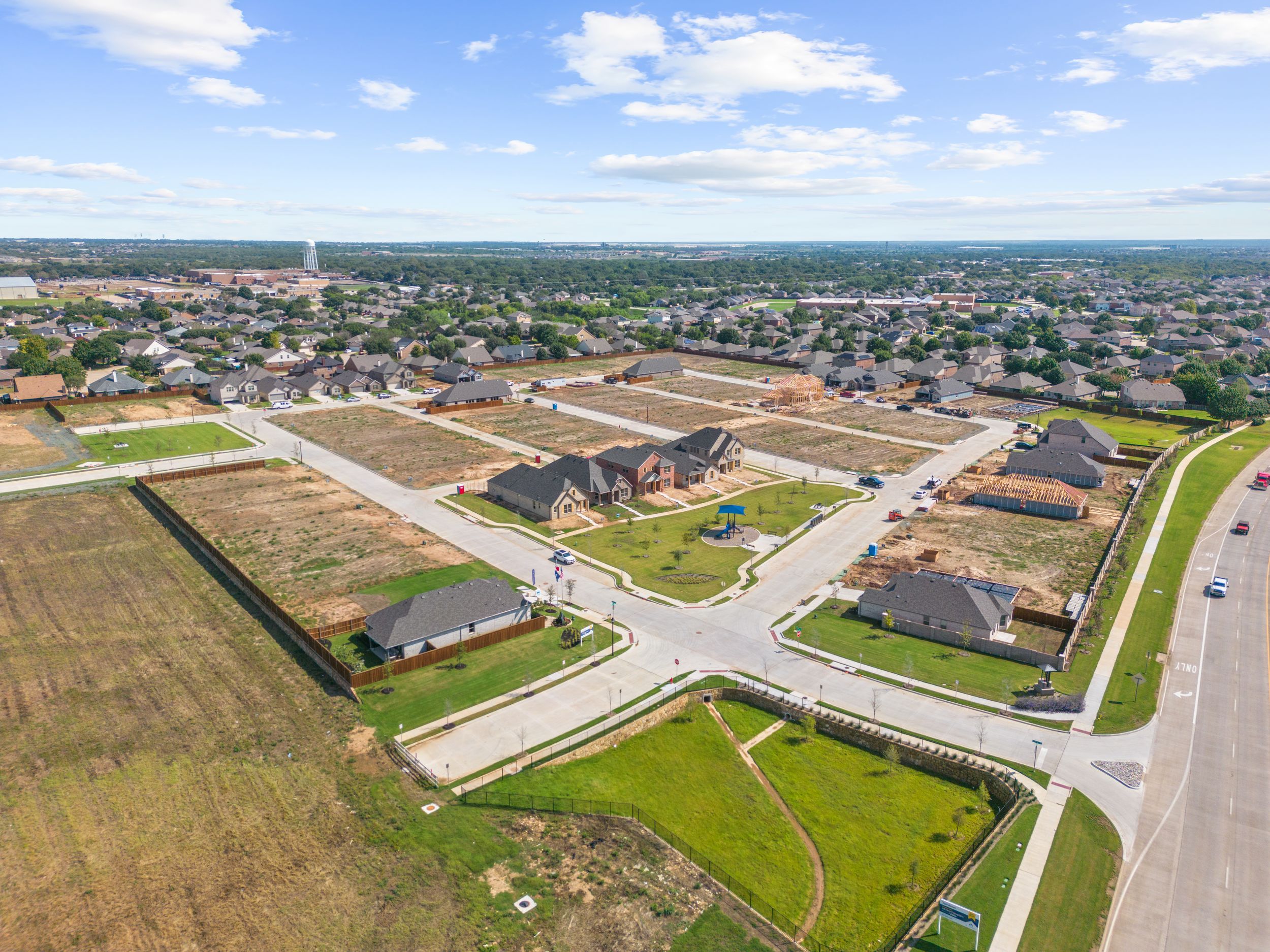 Commercial aerial photography of a suburban development showing residential streets and undeveloped lots.