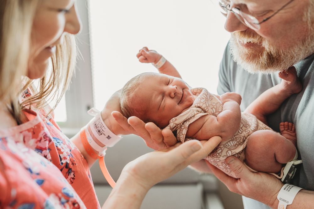 mom and dad holding their newborn at their photography session in tulsa,OK