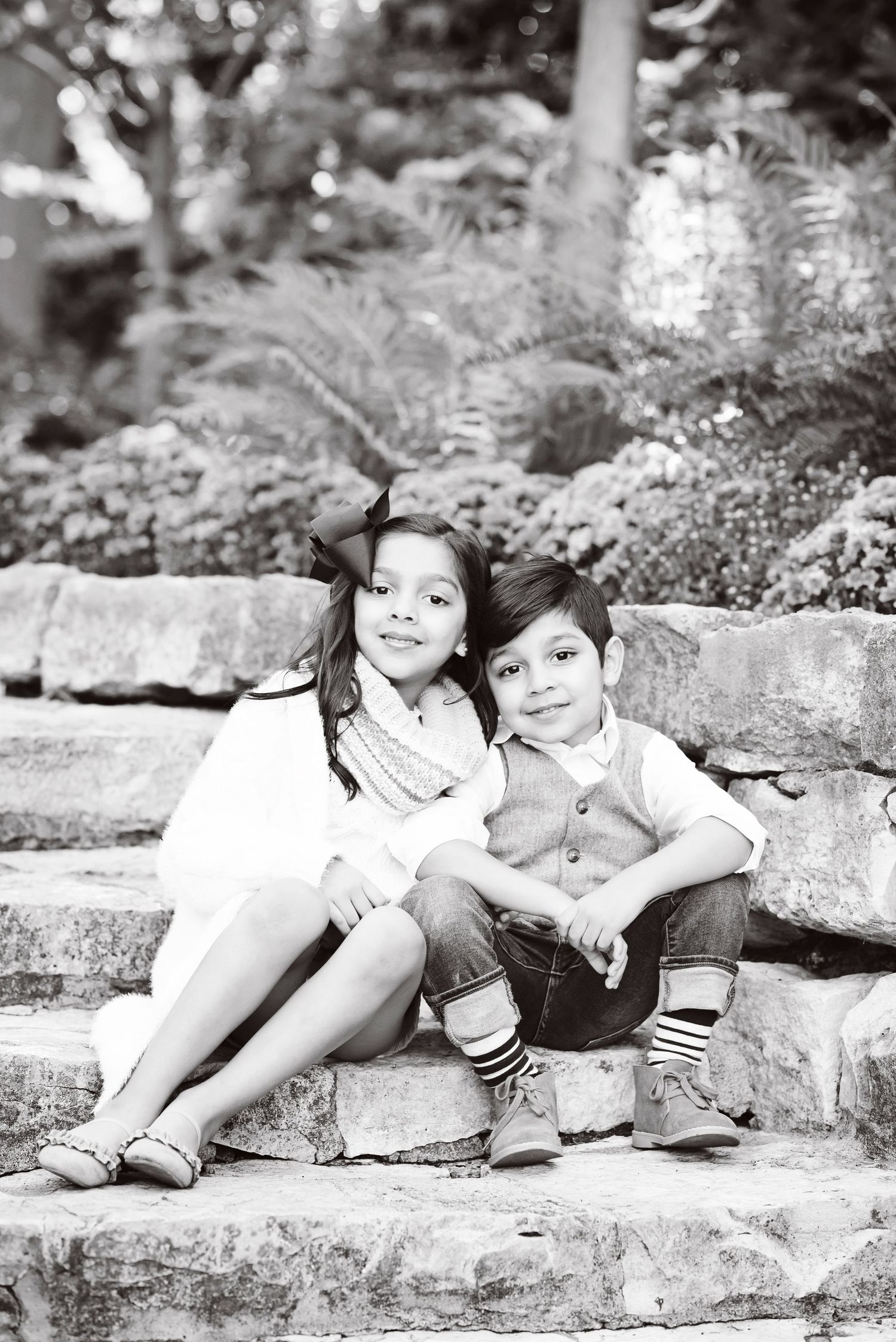 Portrait of two children sitting together on stone steps in a garden outdoors near Hershey PA in Dauphin County.