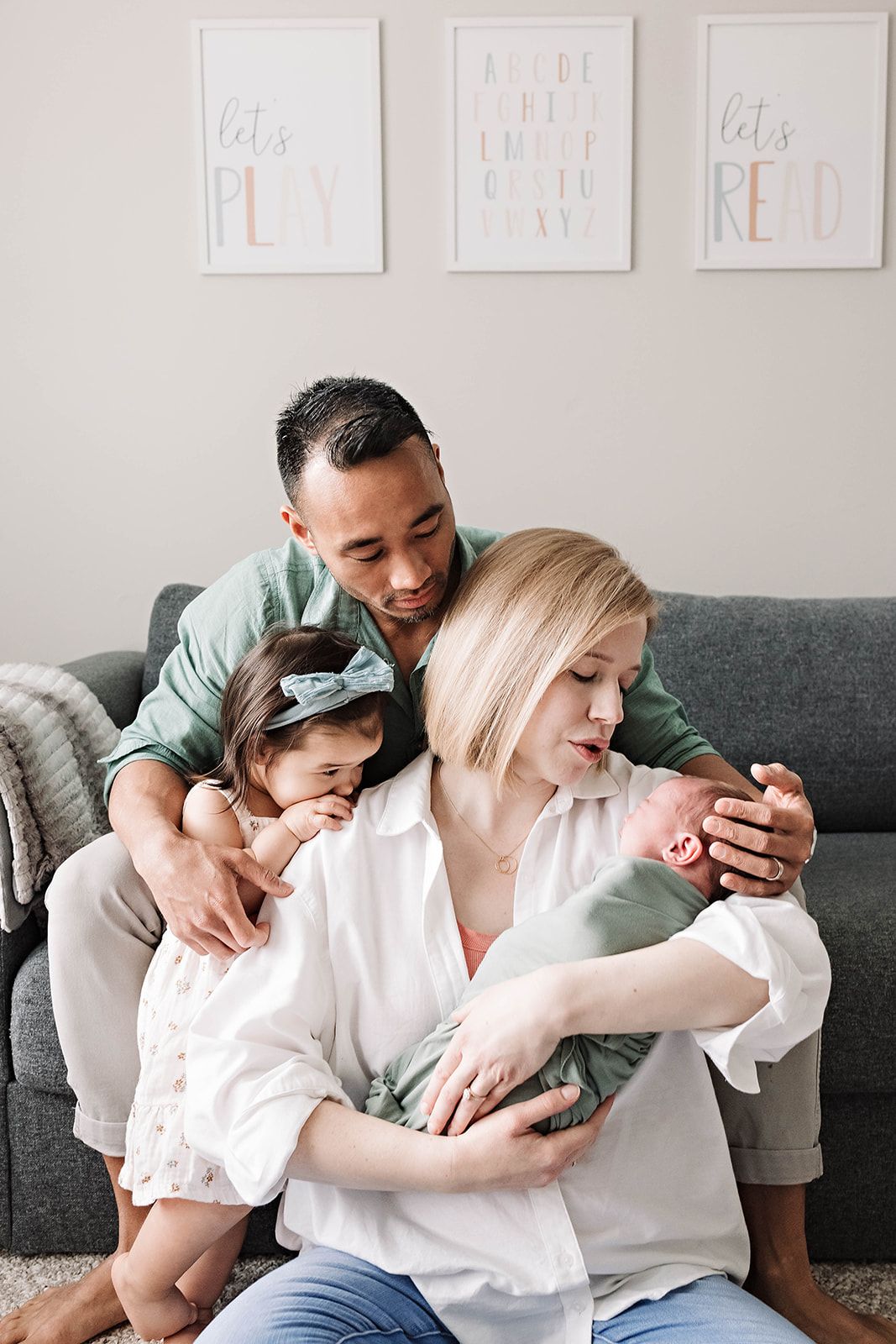 A photo of a  family sharing a tender moment together as they give comfort to their newborn baby in their home near Harrisburg PA.