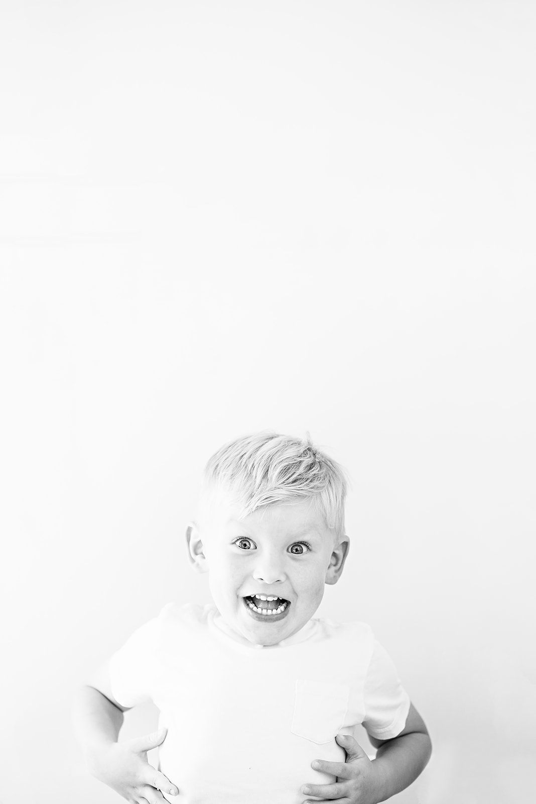 A black and white portrait of a child showing joyful expressions and laughter against a white background near Harrisburg PA.