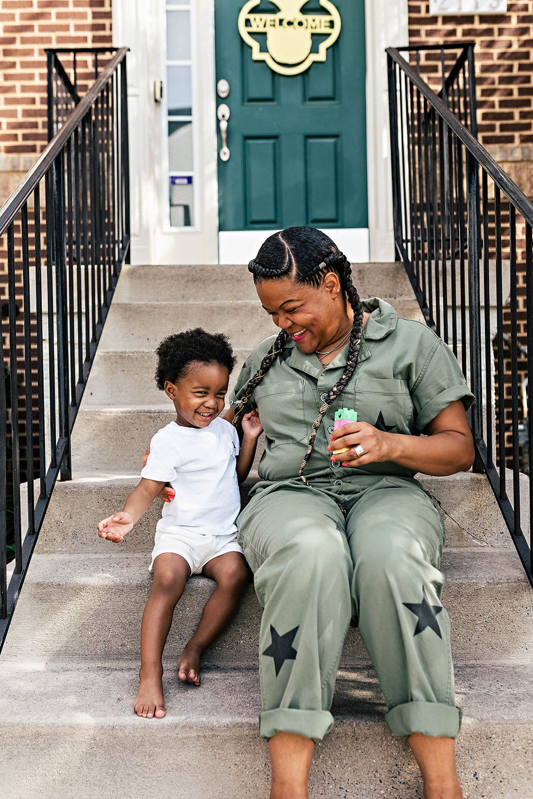 A mother and child share a sweet moment sitting together outside their home, showing a lifestyle of laughter and joy near Harrisburg PA.