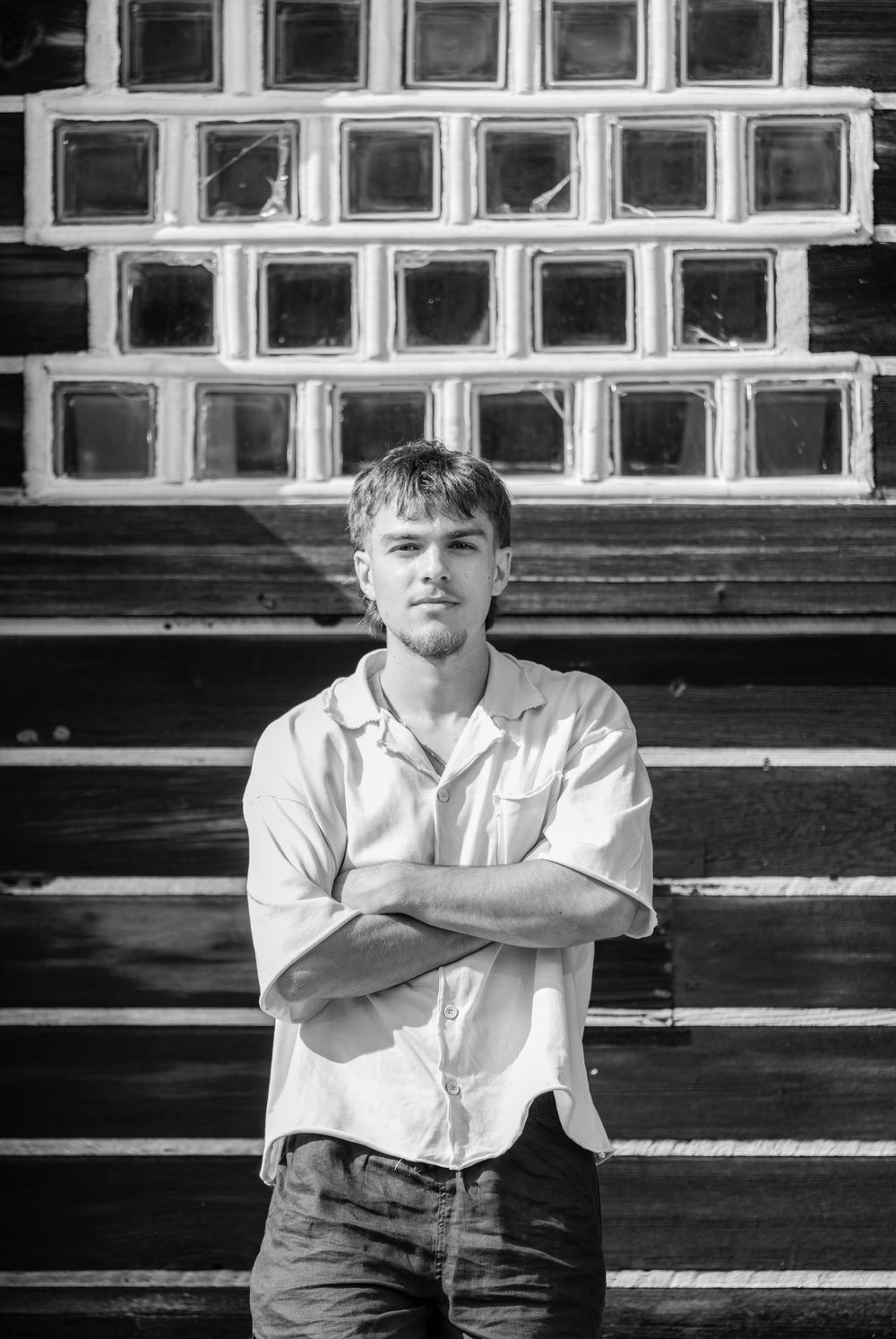 Black and white portrait series of a person in a white shirt sitting on bleacher steps.