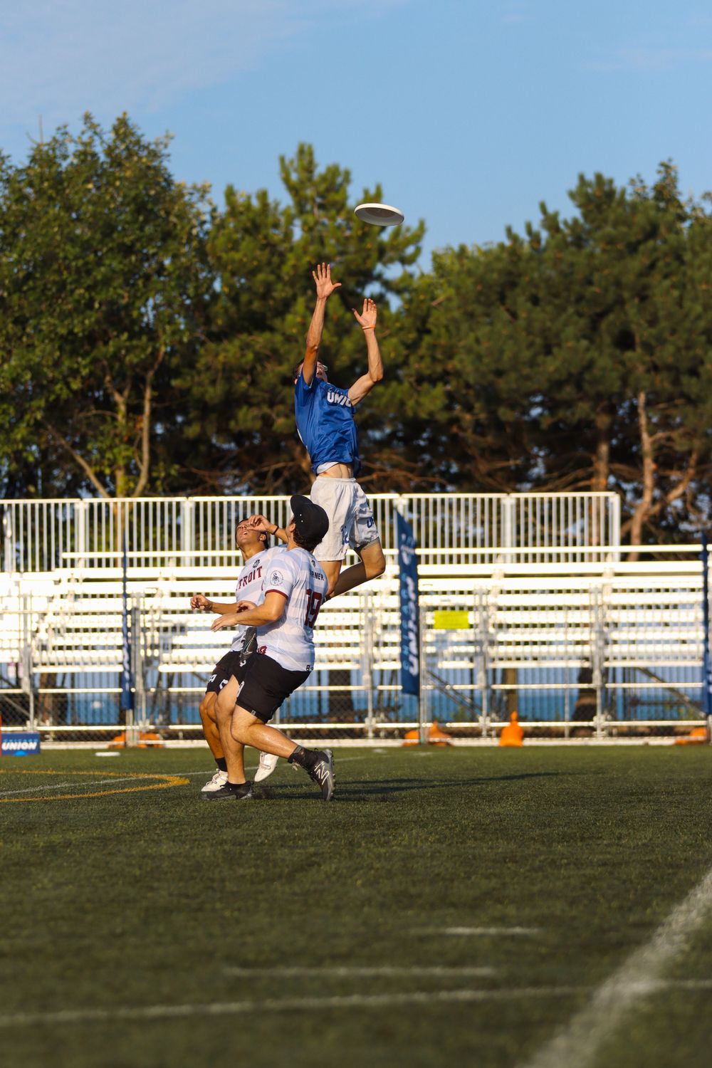 Athletic players making horizontal diving catches during ultimate frisbee competition.