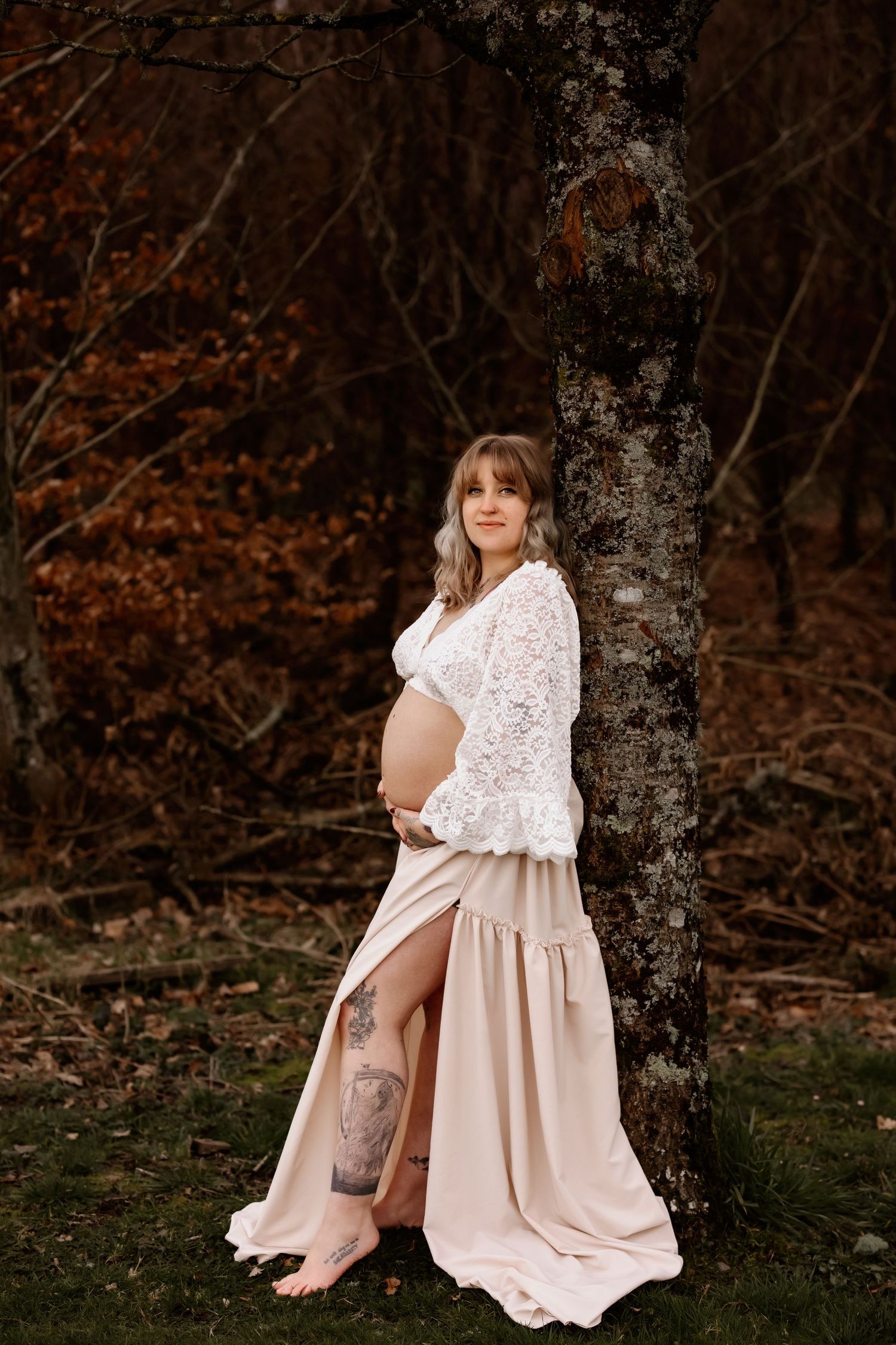 pregnant mum standing against tree