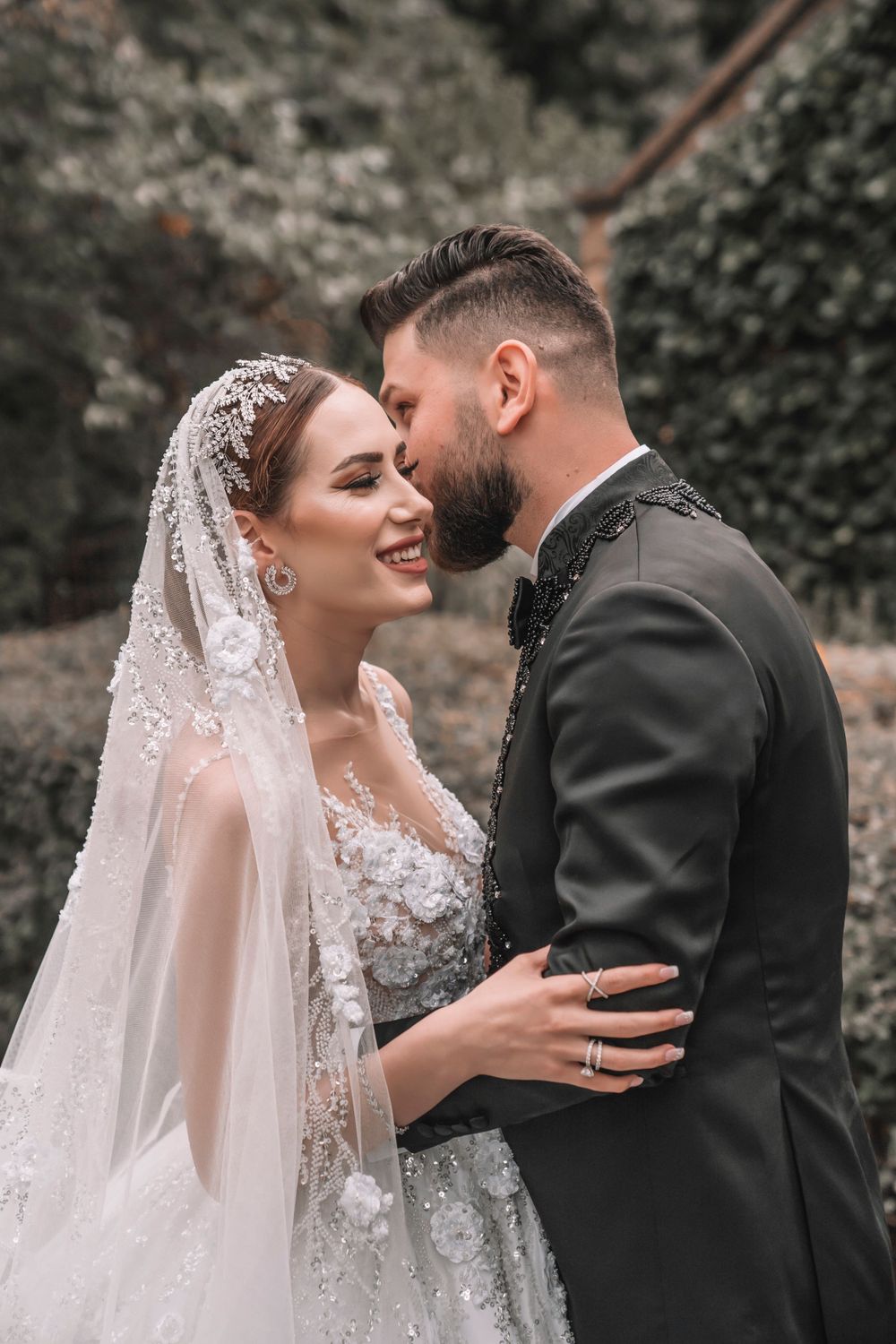An intimate moment between newlyweds in a garden setting with beautiful natural lighting.