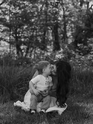 A touching black and white photo series showing tender moments between two people laying in grass outdoors.