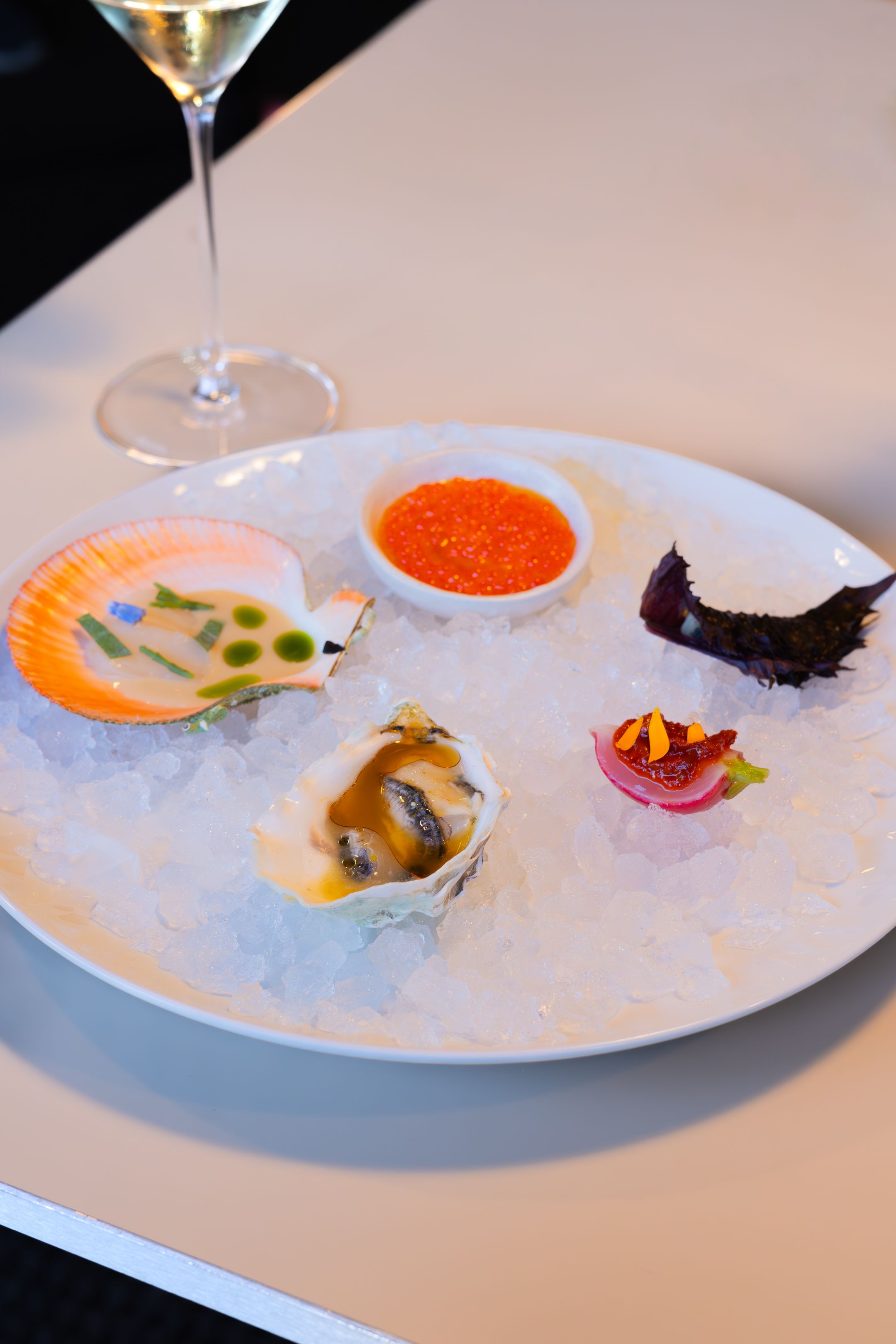Elegant seafood plate with oysters and caviar served on ice.