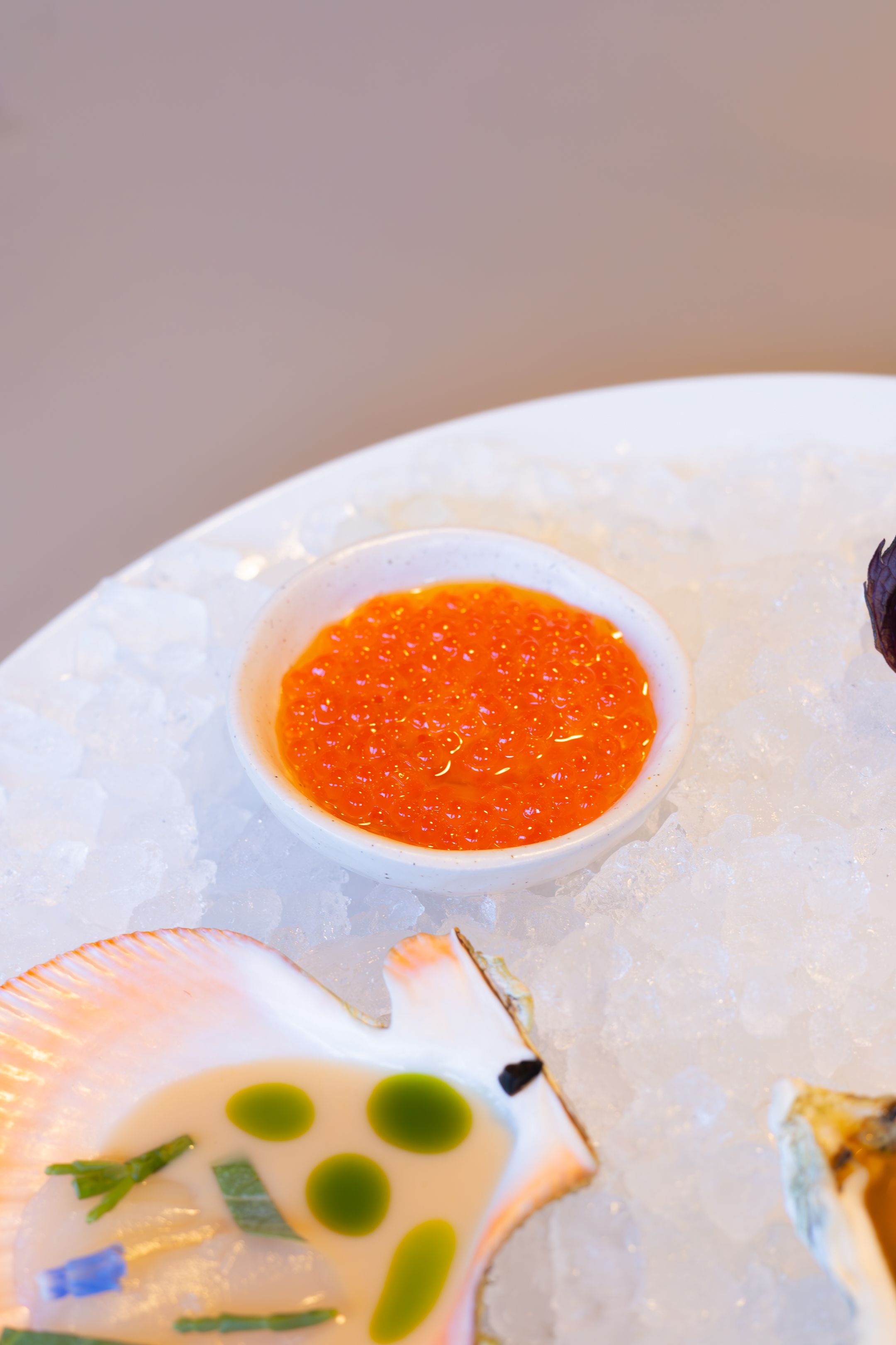 Close-up of seafood appetizer with bright orange caviar sauce.