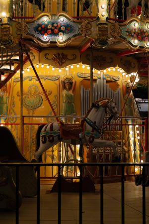 Vintage carousel with ornate decorative horses and traditional fairground design lit up at night.