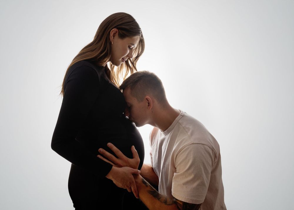 Silhouetted couple in tender embrace shown in sequence of intimate poses against white background.
