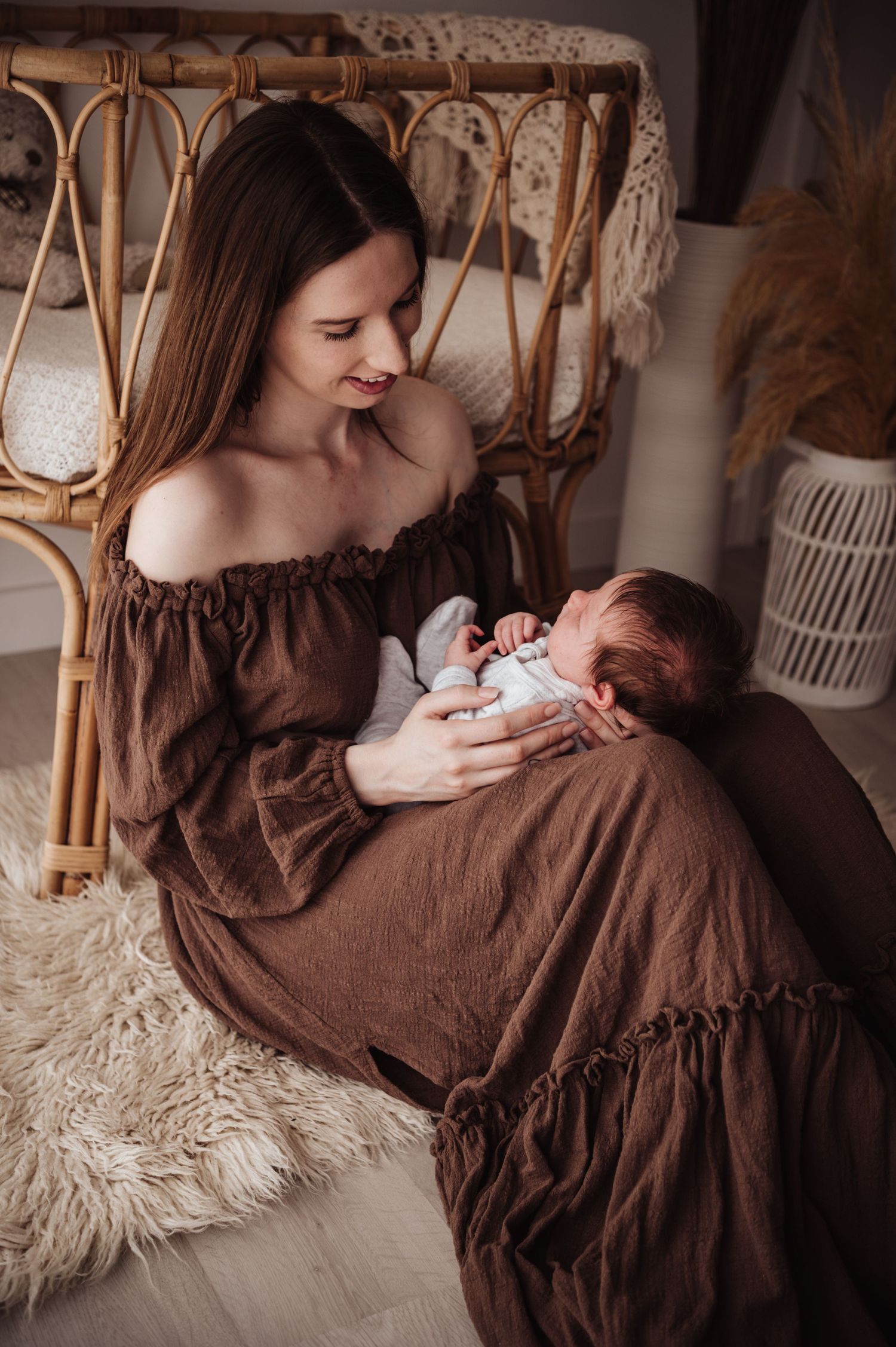 In a cozy rattan chair, intimate bonding moment with a newborn baby in a rustic interior setting.