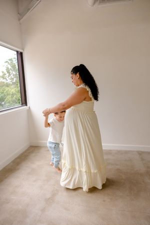 A sequence of dance-like movements captured in a minimalist white room with a window and beige carpet.