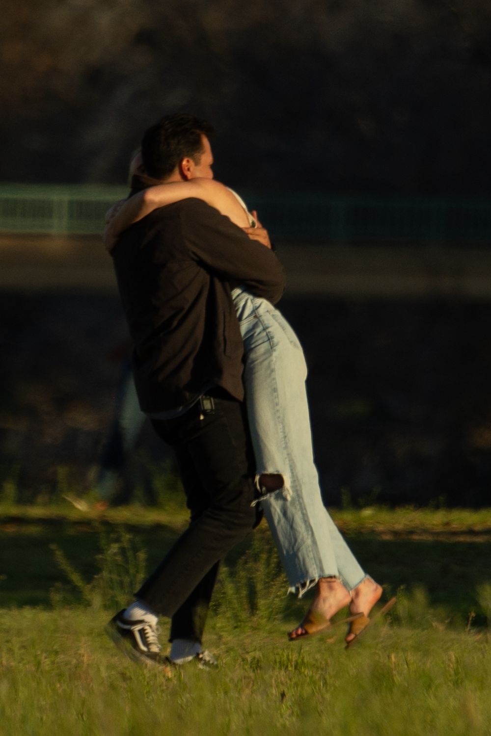 A man twirls his fiancée during a couple photo session in Fort Worth. They are dressed semi-casual cute.