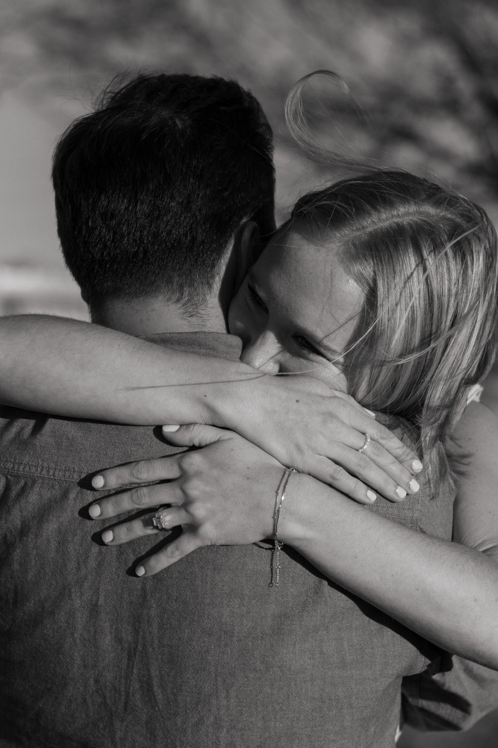 Black-and-white candid photo of a woman tightly hugging her man during a couples session in Panther City, Fort Worth.