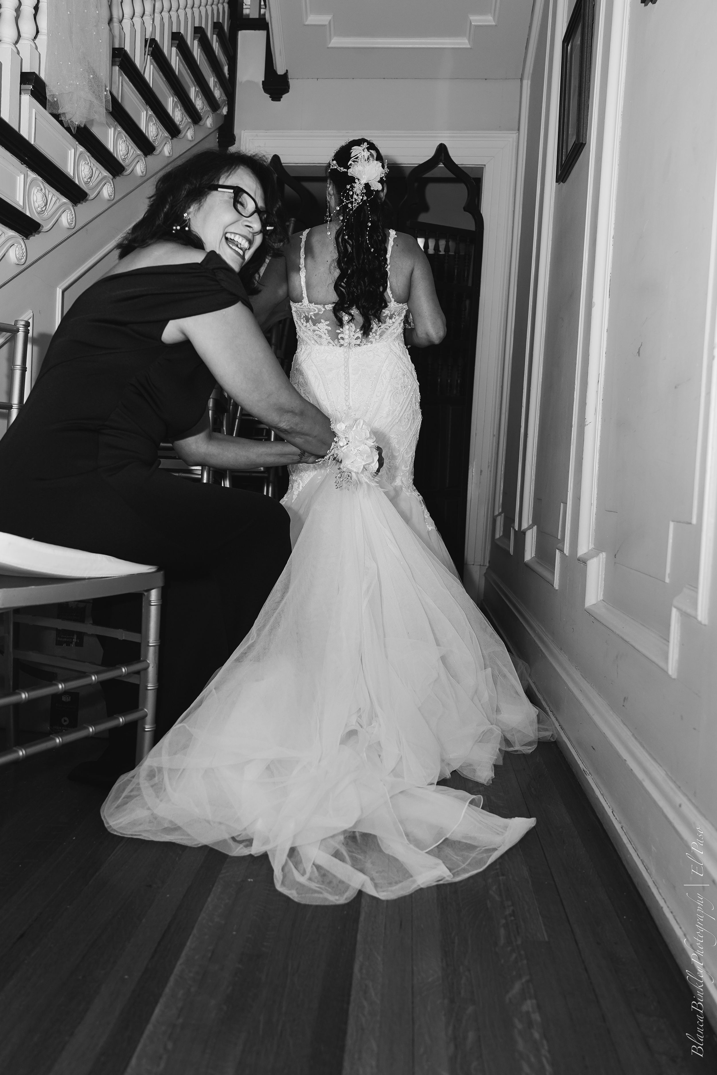 A sequence of black and white photos showing someone in a white wedding dress twirling and dancing in an elegant hallway.