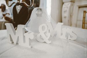 Decorative white Mr and Mrs letters on display against a wooden backdrop.
