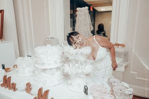 White wedding cake layers and decorations scattered across a light colored floor in an indoor setting.