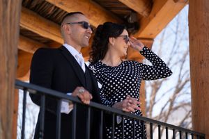 A couple dancing outside under a rustic wooden pavilion with polka dot dress patterns visible.