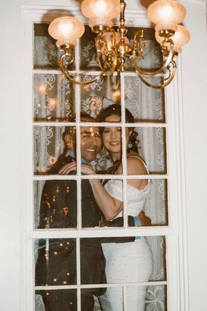 Window views of illuminated lanterns and chandeliers creating a magical glow inside an elegant venue.