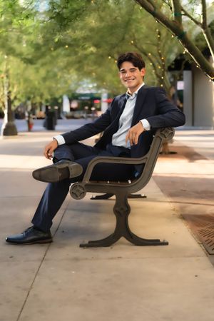 Person in formal attire poses casually on outdoor bench in various relaxed positions.