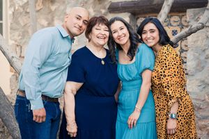 A group of people wearing coordinated blue and yellow outfits pose together for outdoor family photos.