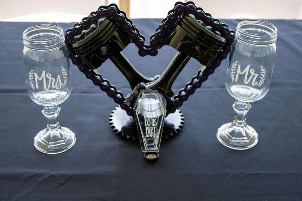 Gothic wedding table setting with black coffin decor and wine glasses on dark tablecloth.