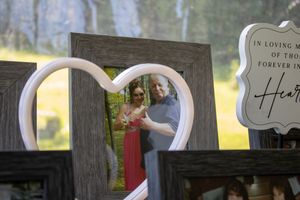 Rustic wooden signs with romantic text displayed on weathered fence posts.