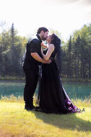 Romantic wedding photo session by a turquoise lake with mountains in the background.