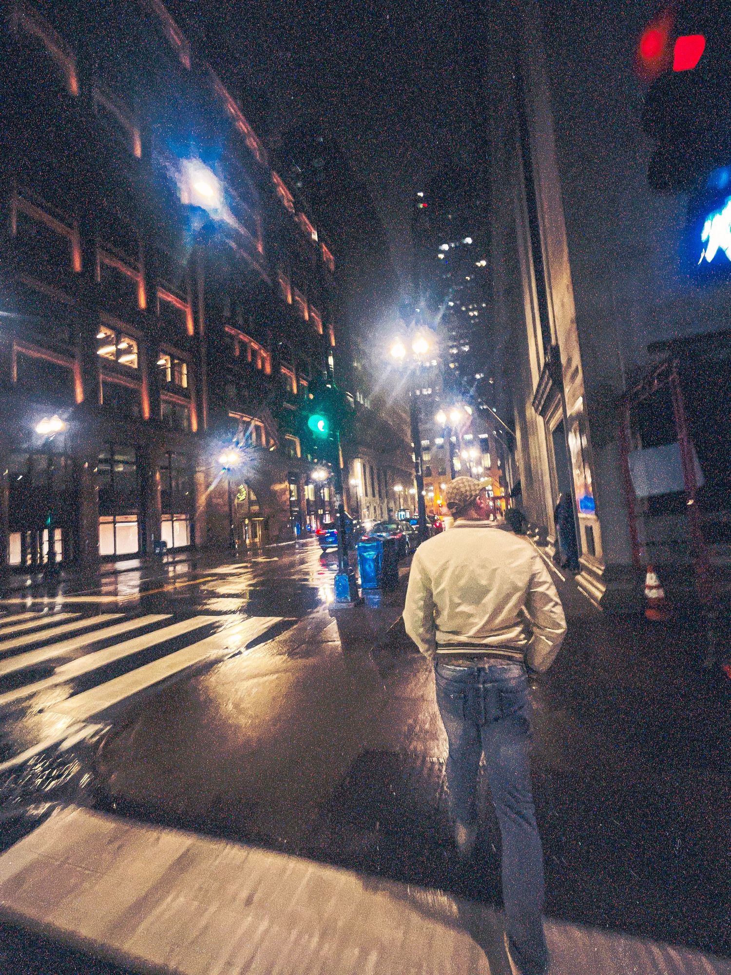 Dark urban street at night with street lamps creating dramatic lighting and shadows.