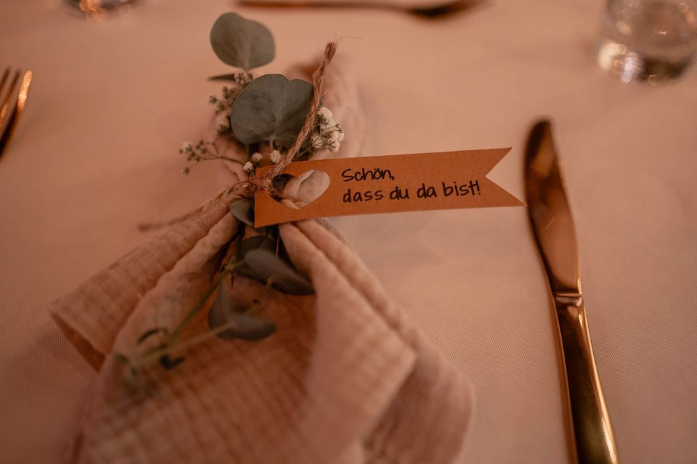 A rustic book page is decorated with dried flowers and eucalyptus, creating a romantic vintage aesthetic.