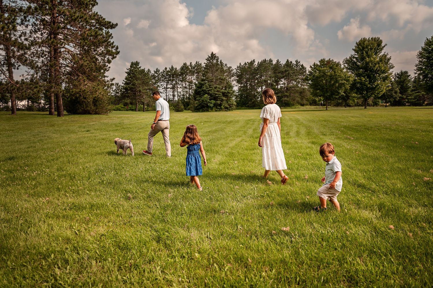 A family shares an intimate moment together in a golden field at sunset.