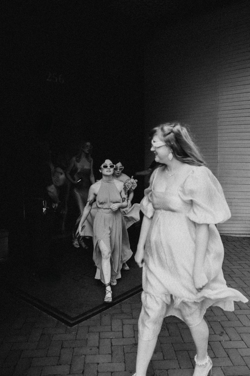 Artistic black and white photo sequence of people in white clothing dancing at night.