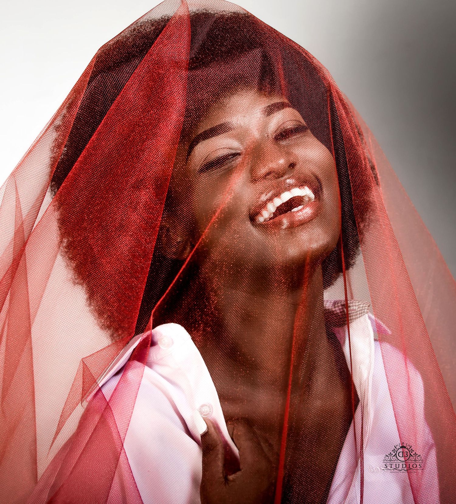 Portrait through red veil showing joyful expressions and movement.
