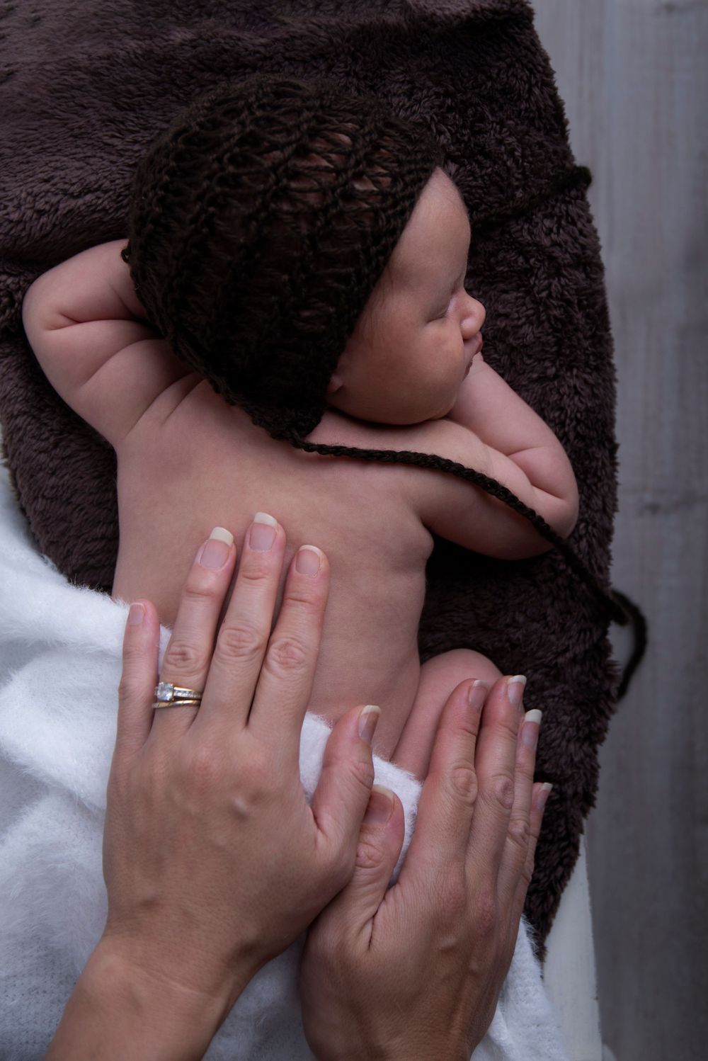 Professional newborn portrait in Gilston home studio with soft cream textures.