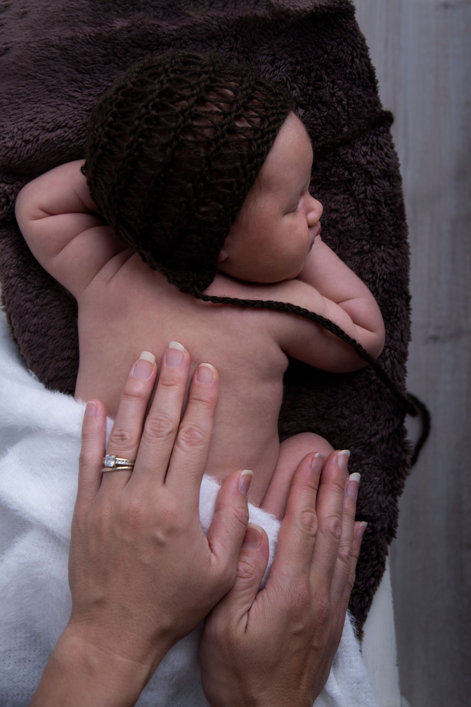 Professional newborn portrait in  home studio with soft cream textures.