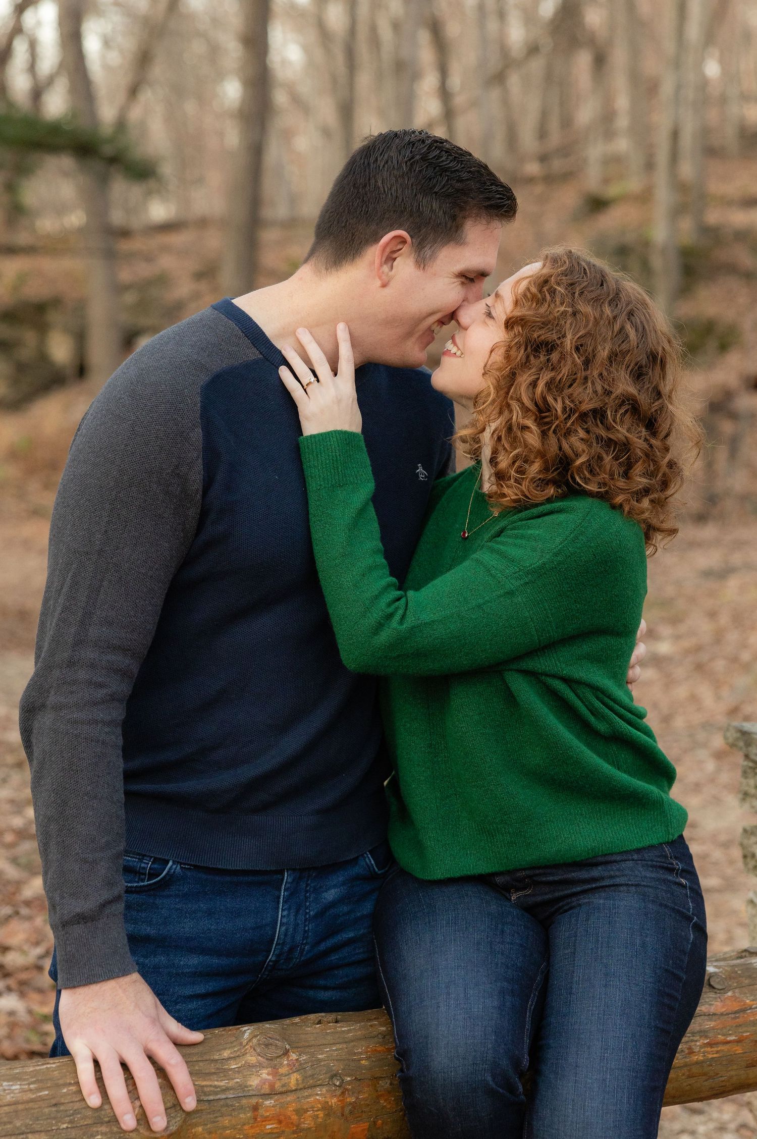 Couple shares intimate moment in sunlit forest setting during golden hour.