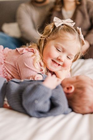 Sweet candid moment of siblings bonding together on couch.