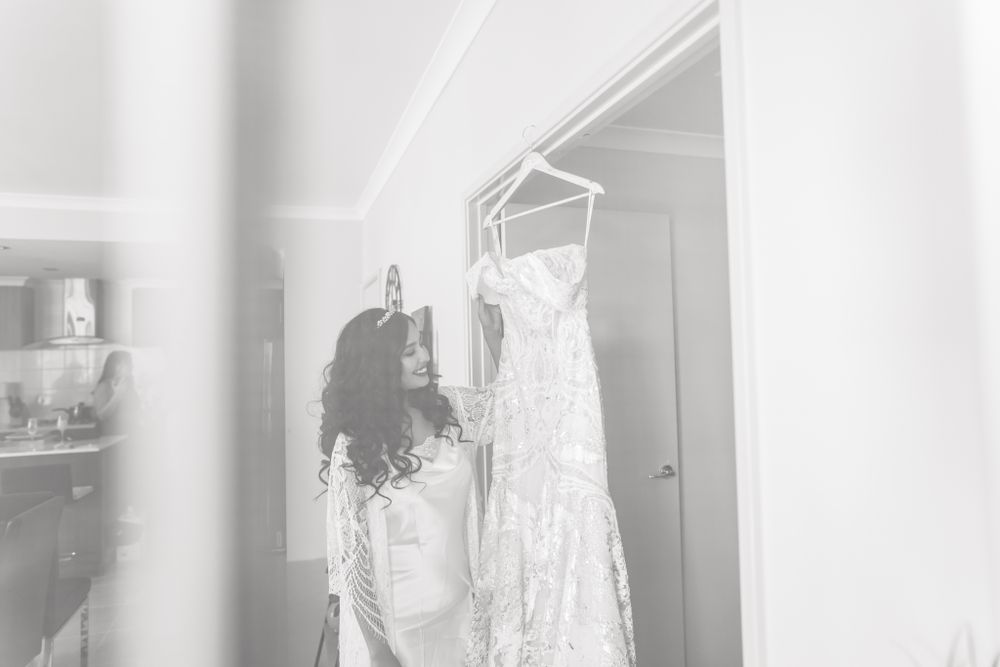 A dreamy, ethereal black and white image of a wedding dress being prepared.