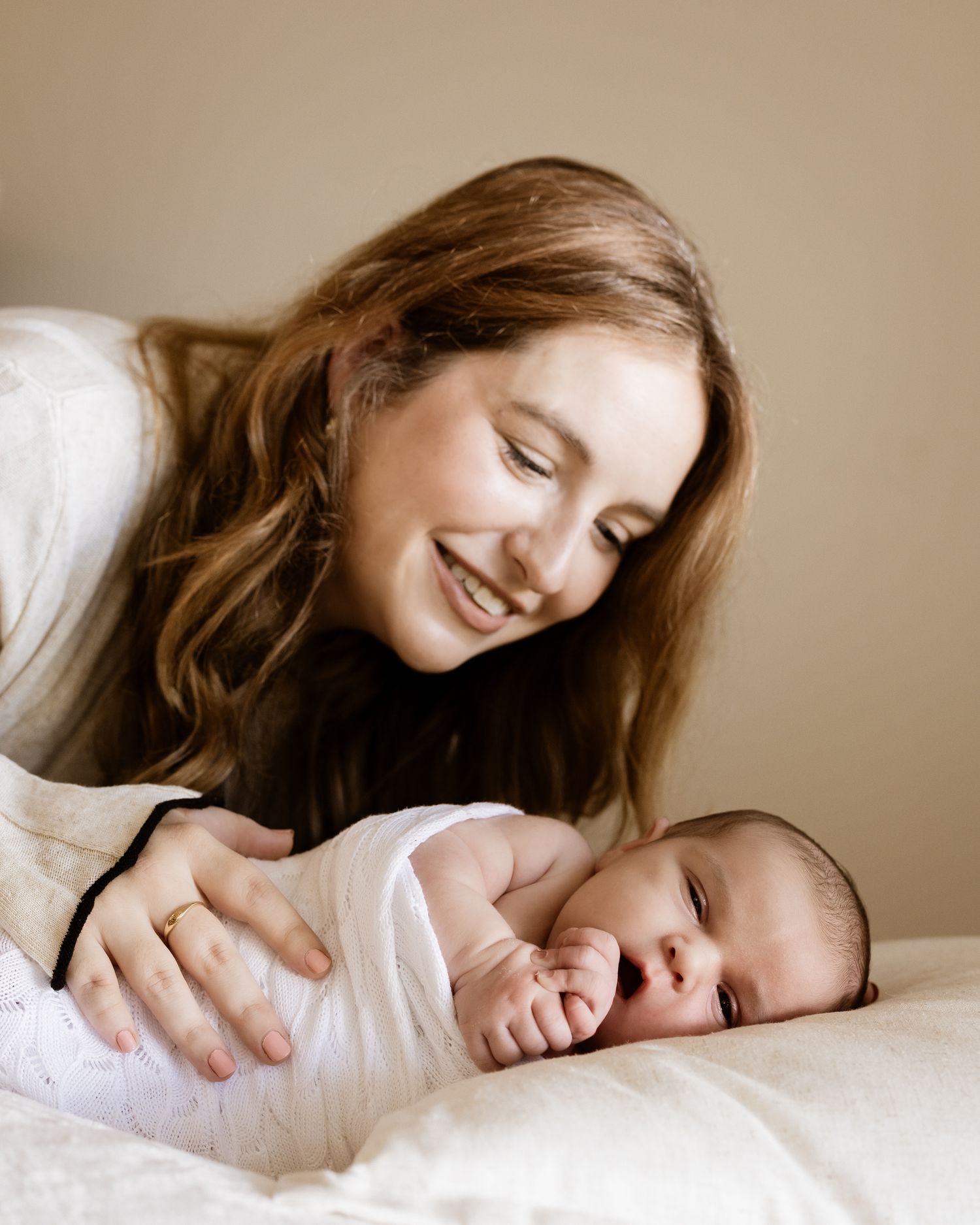 mum holding her newborn in a comfortable home setting in St Ives Chase