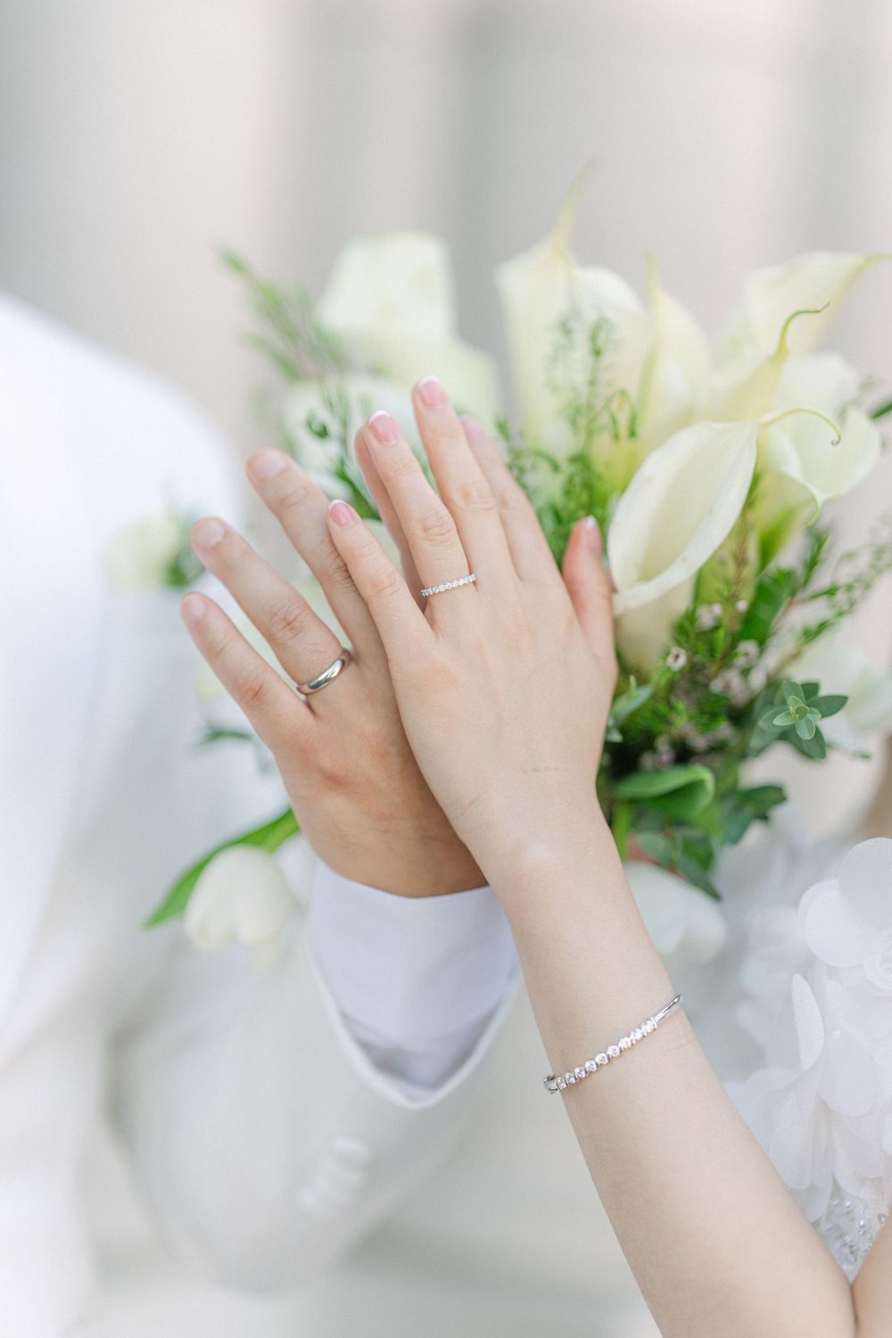 bride holding a white floral bouquet during wedding portrait showing their wedding rings