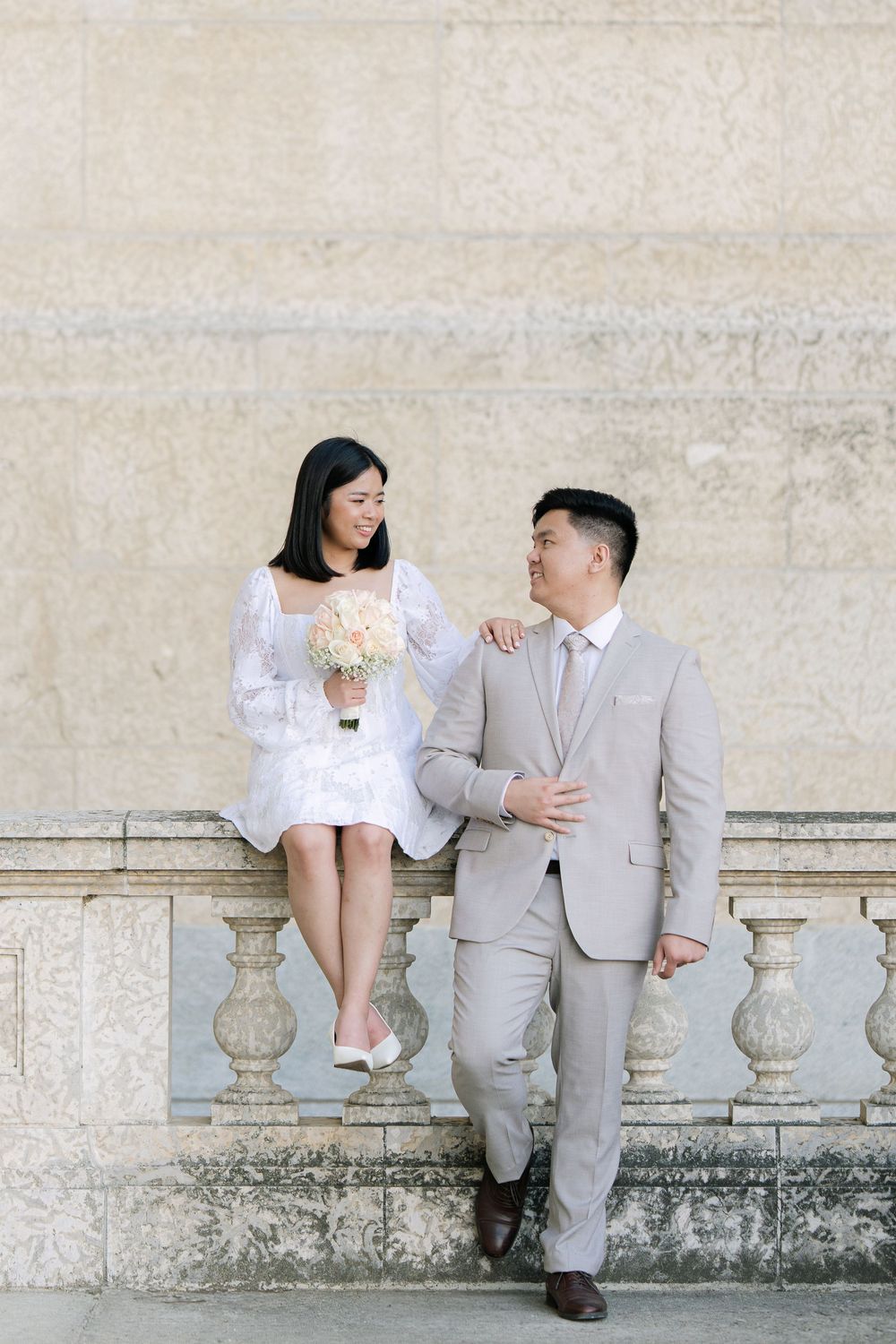 bride and groom seated together during a relaxed wedding portrait session