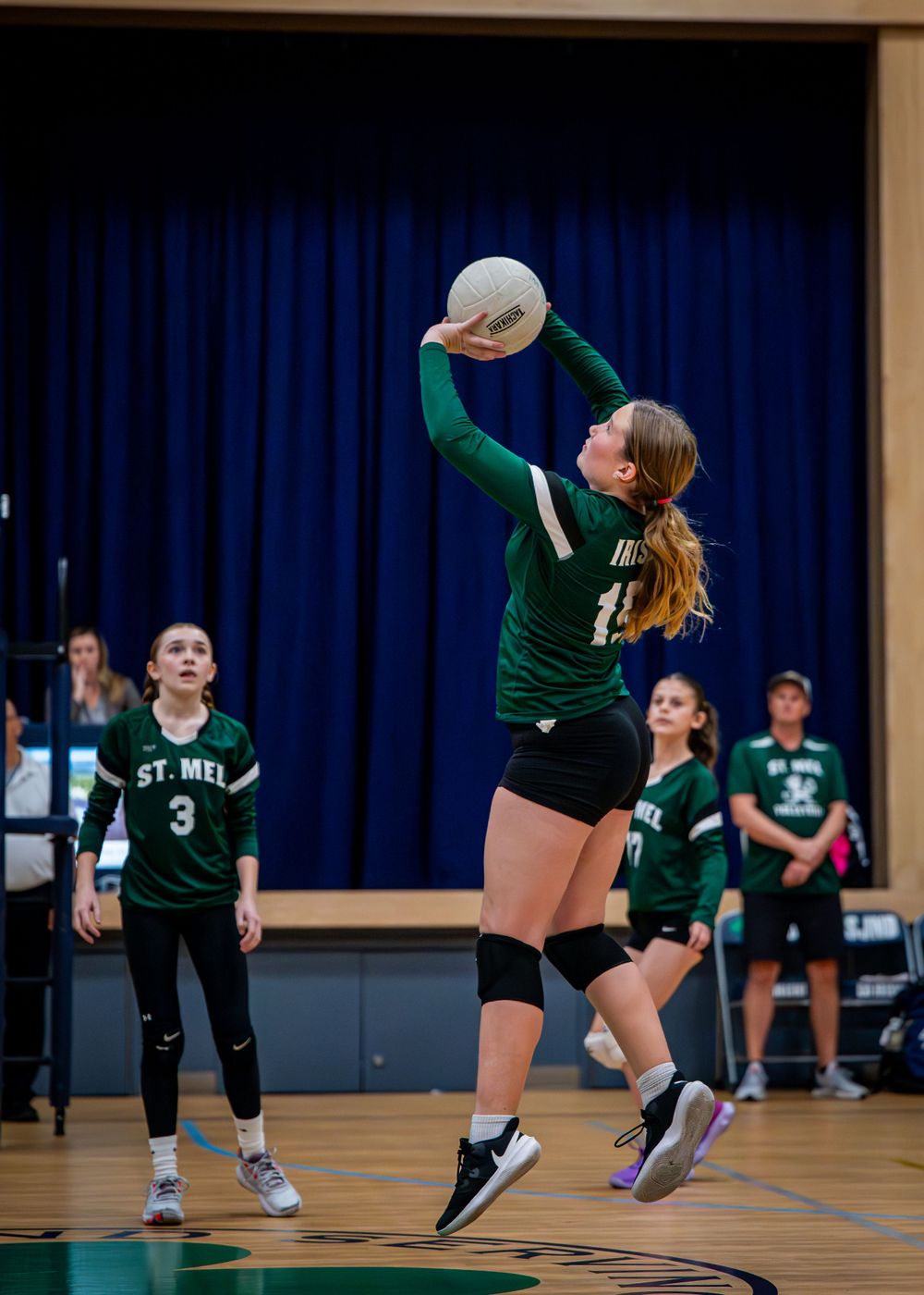 Girl hitting volleyball.