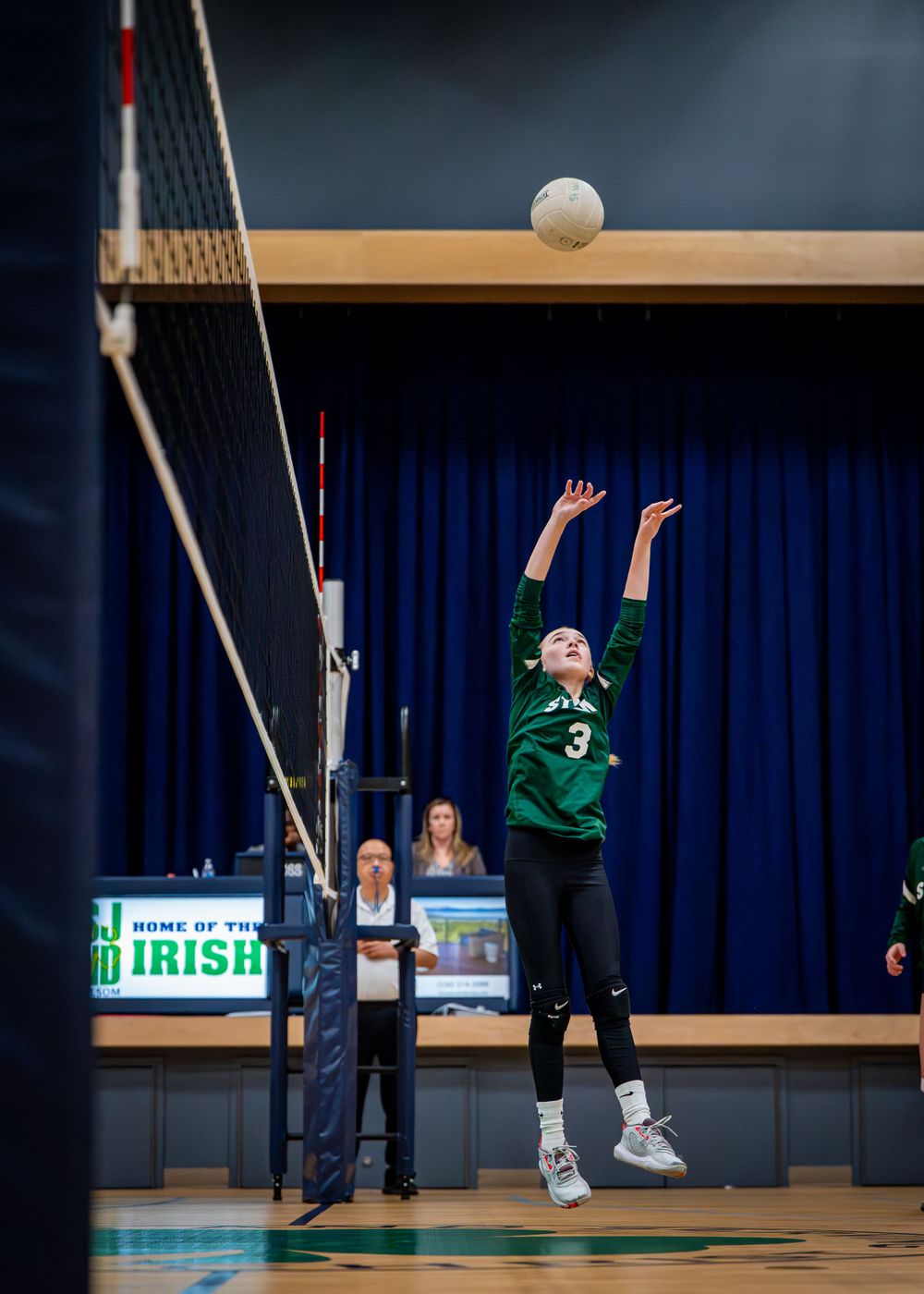 Girl hitting volleyball.
