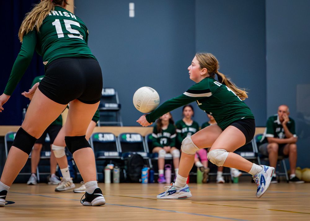 Girl hitting volleyball.