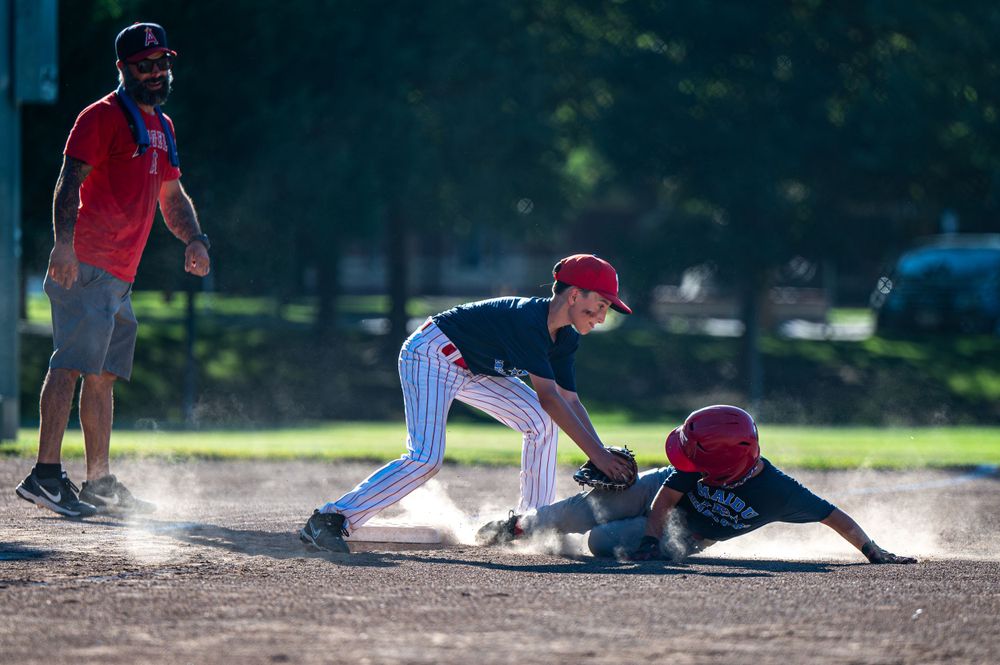 Baseball player stealing third base.