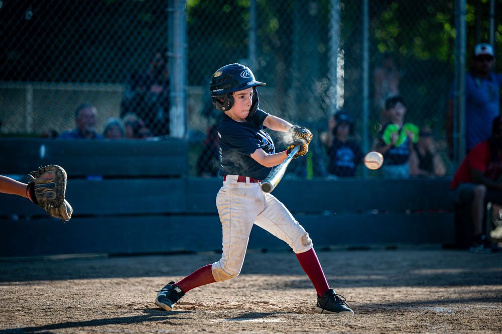 Baseball player hitting ball.