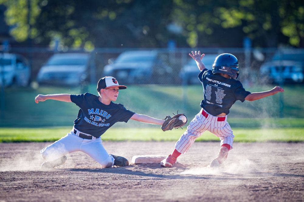 Baseball player stealing second base.